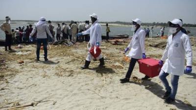 Miembros del Instituto Indio de Investigación de Toxicología de Lucknow recogen muestras de agua del río Ganges, cerca de un campo de cremación también para las víctimas del coronavirus. Foto AFP