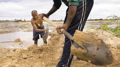 Dos mineros excavan en una veta ilegal de oro en el estado Bolívar.
