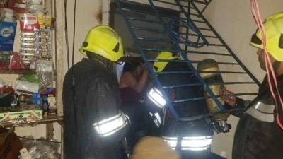 Labor. Los bomberos arrancan unos barrotes para rescatar a las personas atrapadas.