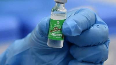 Un trabajador de la salud sostiene un vial de la vacuna Covishield contra el covid-19 de AstraZeneca. Foto AFP