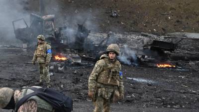 Los miembros del servicio ucraniano buscan y recogen proyectiles sin explotar después de un combate con un grupo de asalto ruso en la capital ucraniana de Kiev.