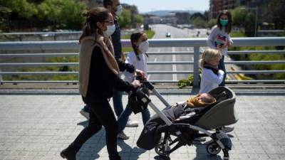 José, de 45 años, empuja el cochecito de su hijo Pol mientras camina con su familia en Barcelona, ​​durante un cierre nacional para evitar la propagación del virus. Foto AFP