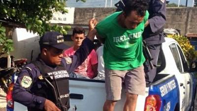 Dos de los apresados cuando eran bajados de una patrulla en la sede de la Policía Nacional de El Progreso.