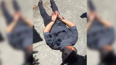 El joven capturado vestía una camisa gris, pantalón azul oscuro y lentes negros.