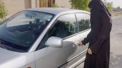 Una mujer saudí abre la puerta de un coche familiar en Riad, Arabia Saudi. EFE/Archivo