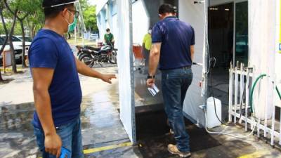 En San Pedro Sula varios comercios e instituciones gubernamentales ya cuentan con túneles de desinfección previo a ingresar a sus instalaciones. Fotos: Frankly Muñoz