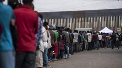 Migrantes centroamericanos hacen fila para buscar comida fuera de un refugio en Tijuana. AFP / P. Pardo