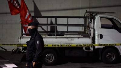 Policías custodian un camión que transportaba simpatizantes del partido político Frente Farabundo Martí (FMLN), atacado con armas de fuego cuando regresaba de la actividad política, cerca del Hospital Rosales, en San Salvador. Foto AFP