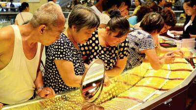 Potenciales compradores inspeccionan collares en una joyería en la provincia de Henan, China, a comienzos de este mes. Una gran transacción en Shanghai en julio fue la evidencia de la ascendente influencia de ese país en el negocio del oro.