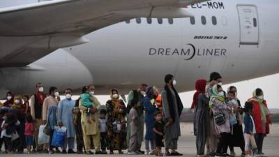 Los refugiados hacen cola en la pista después de desembarcar de un vuelo de evacuación de Kabul. Foto AFP