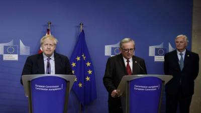 El primer ministro británico, Boris Johnson y el presidente de la Comisión Europea, Jean-Claude Juncker, son vistos por el negociador del Brexit de la UE, Michel Barnier (R), mientras se dirigen a una conferencia de prensa en una Cumbre de la Unión Europea en la sede de la Unión Europea en Bruselas. Foto AFP