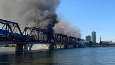 Gruesas columnas de humo negro debido al aparatoso incendio en el puente que atraviesa el lago Tempe Tow, cercano a la ciudad de Phoenix (Arizona), causado por el descarrilamiento de un tren. EFE
