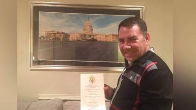 Virgilio Paredes al mostrar su tarjeta de invitación a la toma de posesión de Donald Trump.