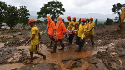 El personal de Target Disaster Response Force (TDRF) transporta el cuerpo de una víctima en un lugar de deslizamiento de tierra en Taliye, a unos 22 km de la ciudad de Mahad. Foto AFP