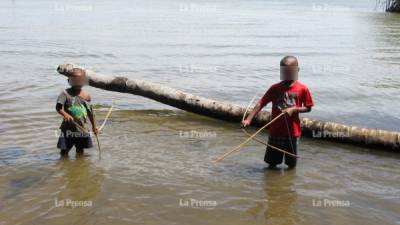 Con arco y flecha, niños misquitos pescan en la laguna de Caratasca.