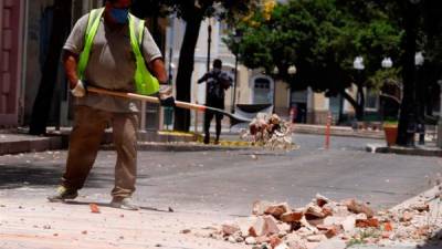 Personas limpian estructuras históricas afectadas por un temblor en el centro de Puerto Rico.