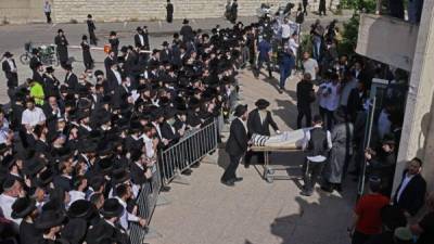 Hombres judíos ultraortodoxos participan en una ceremonia fúnebre en Jerusalén por una víctima de una estampida nocturna durante una reunión religiosa. Foto AFP