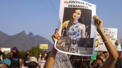 Personas sostienen carteles mientras participan en la marcha de mujeres exigiendo justicia para Debanhi Escobar.