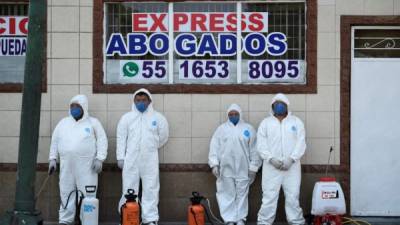 Los trabajadores de la salud descansan mientras desinfectan el barrio de Iztapalapa dentro de las medidas sanitarias contra el coronavirus COVID-19, en la Ciudad de México. Foto AFP