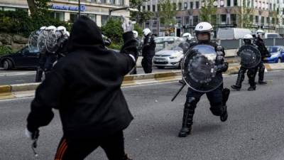 Un manifestante se pelea con equipo antidisturbios durante una protesta contra el racismo. Foto AFP