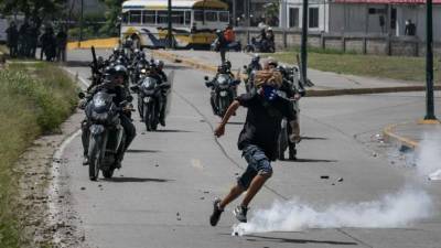 Un manifestante es perseguido por efectivos de la policía durante una protesta opositora en Caracas (Venezuela). EFE