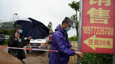 El personal de seguridad usa cinta perimetral para acordonar la entrada a la aldea de Lv que conduce al lugar del accidente del vuelo MU5375 de China Eastern en Wuzhou.