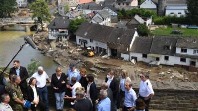 La canciller alemana Angela Merkel y el primer ministro del estado de Renania-Palatinado Malu Dreyer hablan mientras permanecen en un puente durante su visita a las áreas devastadas. Foto AFP