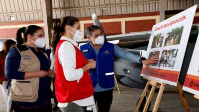 Juan Orlando Hernández mostrándole a la Reina Letizia fotografías de la devastación dejada por las tormentas en el país.