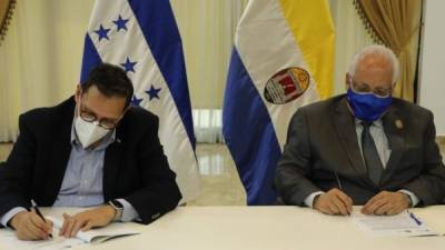 El canciller Lisandro Rosales y el rector Francisco Herrera firmando el convenio.