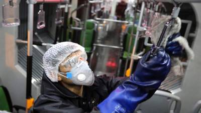 Un trabajador del municipio de Teherán limpia un autobús para evitar la propagación de la enfermedad COVID-19. Foto AFP