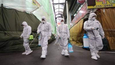 Los trabajadores de un mercado usan desinfectante protector en aerosol en la ciudad de Daegu, en el sureste de Corea del Sur. Foto AFP