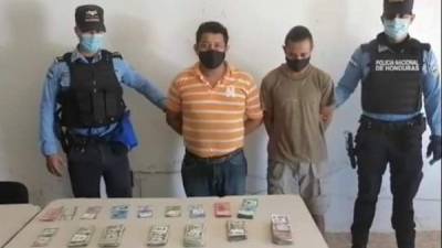 Siendo presentados por la Policía tras su detención y el decomiso del dinero.