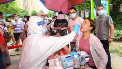 Una residente recibe una prueba de ácido nucleico contra el coronavirus en Wuhan, en la provincia central de Hubei. Foto AFP