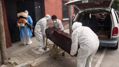 Empleados funerarios retiran el cuerpo de un hombre de 73 años.