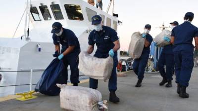 Varios tripulantes del barco Pelican de la Guardia Costera estadounidense mientras descargan bolsas con cerca de una tonelada de cocaína. EFE/Ashley J. Johnson/Guardia Costera de USA