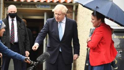 El primer ministro británico, Boris Johnson bromea con un periodista cuando es recibido por un partidario Kelly Whitfield y su hijo Jonny, de 2 años, al salir del pub Jacksons Wharf en Hartlepool. Foto AFP