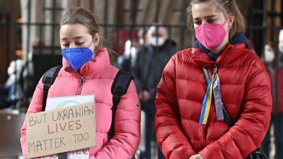 Dos mujeres jóvenes observan un minuto de silencio interconfesional durante el desarrollo de los ataques contra Ucrania.