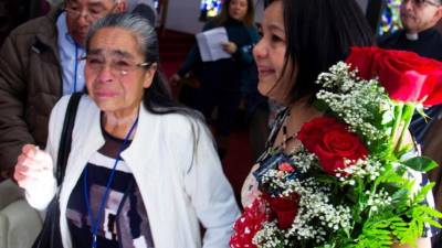 Isidora Pérez (d) recibe a su madre Berta Ramírez (c) y a su padre Juan Pérez (atrás) en un centro comunitario de Pasadena. EFE
