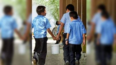 Los alumnos se ven obligados a acarrear agua para limpiar los sanitarios de la escuela desde el pasado lunes, cuando les cortaron el servicio por una mora de 790,000 lempiras.