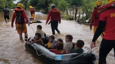 Niños son trasladados a bordo de una balsa inflable en la zona sur de Honduras.