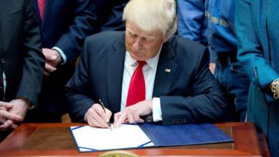 El presidente Donald J. Trump (c), firma la Resolución H.J. 38, desaprobando la regla presentada por el Departamento del Interior de EUA. EFE