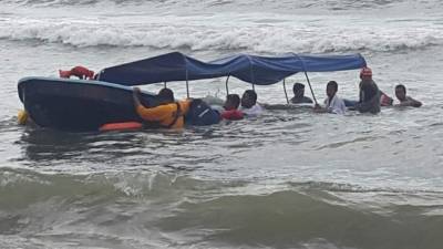Momentos en que los cuerpos de socorro intentan llevar lancha a la orilla.