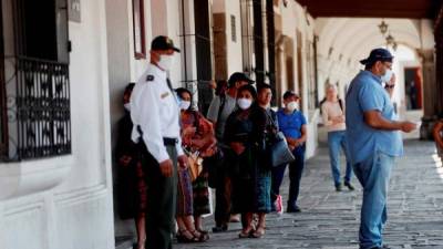 Pobladores de Antigua Guatemala esperan en fila para entrar a un banco en Antigua Guatemala (Guatemala).