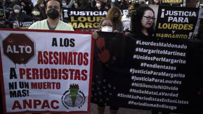 Periodistas y simpatizantes sostienen carteles mientras protestan por los asesinatos de sus colegas Lourdes Maldonado y Margarito Martínez, frente al edificio de la fiscalía federal en Tijuana, Baja California, México.