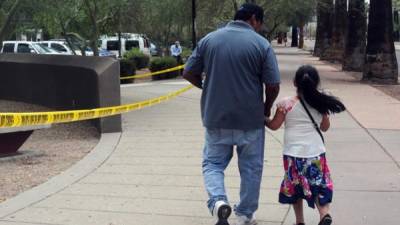 Un hombre camina junto a su hija tras salir de una cita en la Oficina de Control de Inmigración y Aduanas.