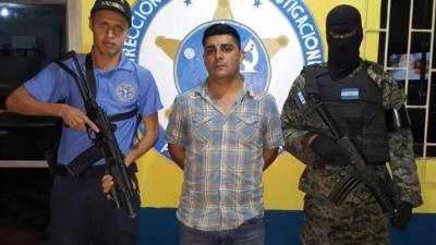 El detenido por el supuesto delito de lavado de activos es custodiado por agentes de la Policía Nacional de Honduras.