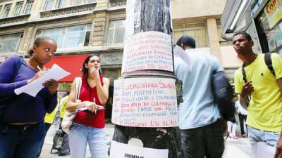 Brasileños leen ofertas de trabajo colocadas en un poste en una calle de São Paulo. El desempleo en el país llega a 9,5%.