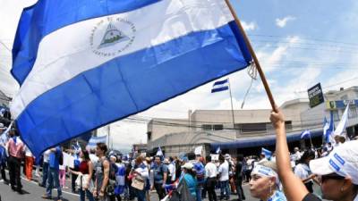 Mujer ondeando la bandera de Nicaragua (AFP)