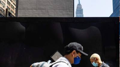 Personas con máscaras caminan en Nueva York.
