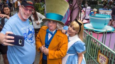 Esta foto cortesía de Disney muestra a Jeff Reitz, en una selfie con El Sombrerero Loco y Alice. EFE
